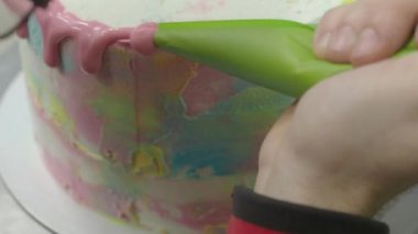 Pasta tasarımcısı Pinl sarı mercan rengi boru tipi 4K görüntülerle süslenmiş kişniş katmanlı pasta hazırlıyor.