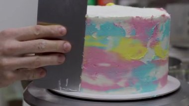 Pasta tasarımcısı Pinl sarı mercan rengi boru tipi 4K görüntülerle süslenmiş kişniş katmanlı pasta hazırlıyor.