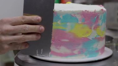 Pasta tasarımcısı Pinl sarı mercan rengi boru tipi 4K görüntülerle süslenmiş kişniş katmanlı pasta hazırlıyor.