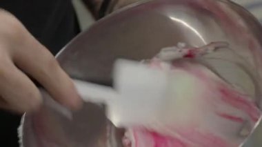 Pastacı el kremalı pastayı kremayla kaplıyor. Laboratuvarda krema doluyor.