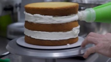 Pasta tasarımcısı çilek ve kremayla doldurulmuş uzun katmanlı pasta hazırlıyor. 4k dekorasyonundan önce pasta yapısı