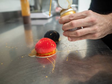 Altın fırça darbeleriyle doldurulmuş kırmızı kadife spreyli tatlı kurabiye kalbi.