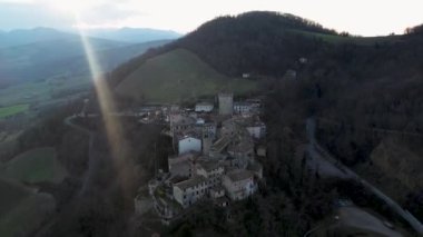 Vigoleno, İtalya - 30 Ocak 2023 Parma tepelerindeki Vigoleno kalesi, kale ve köy manzaralı hava aracı manzarası, Emilia Romagna, İtalya, gün batımı.