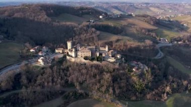 Vigoleno, İtalya - 30 Ocak 2023 Parma tepelerindeki Vigoleno kalesi, kale ve köy manzaralı hava aracı manzarası, Emilia Romagna, İtalya, gün batımı.