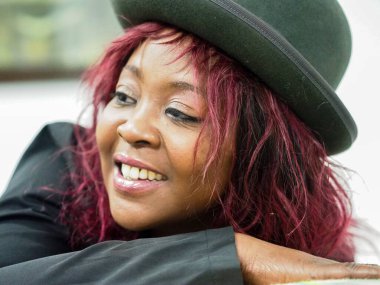 portrait of cheerful young african female model red hair style over white background expressing happiness