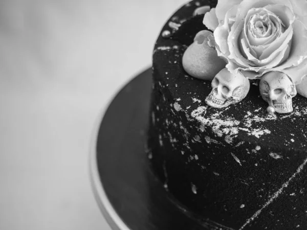 生日黑漆漆糖霜蛋糕 两个真正的玫瑰银粉喷雾和食用巧克力头盖骨和银刷笔划 — 图库照片