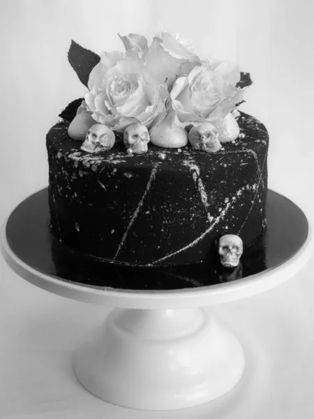 生日黑漆漆糖霜蛋糕 两个真正的玫瑰银粉喷雾和食用巧克力头盖骨和银刷笔划 — 图库照片