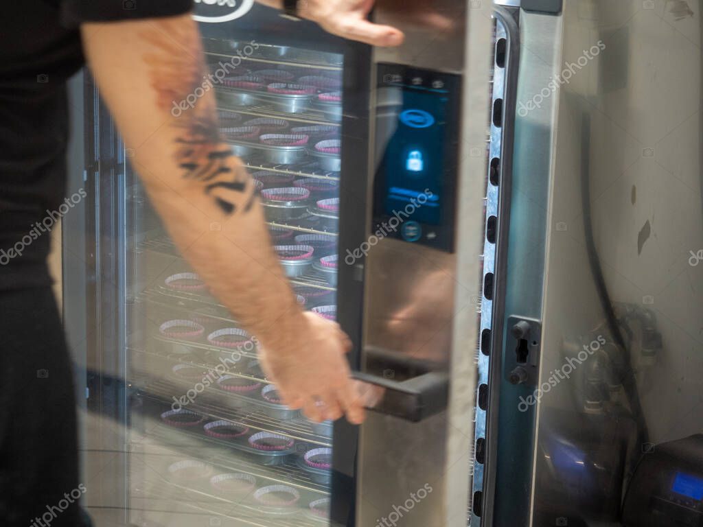 pastelero hornear un gran grupo de pastelitos rellenos de terciopelo