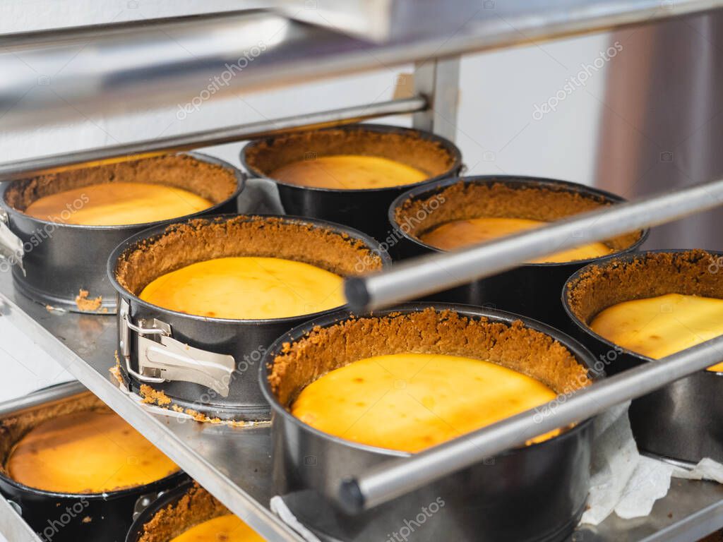 pastelero horneando un gran grupo de pastelitos rellenos de terciopelo
