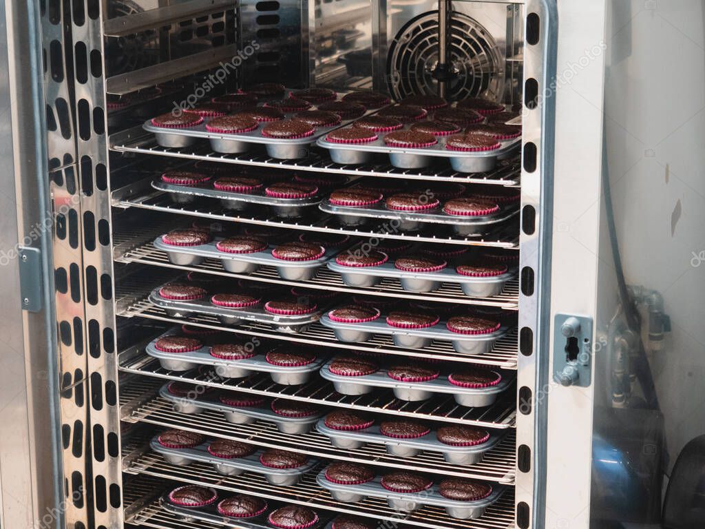 pastelero hornear un gran grupo de pastelitos rellenos de terciopelo