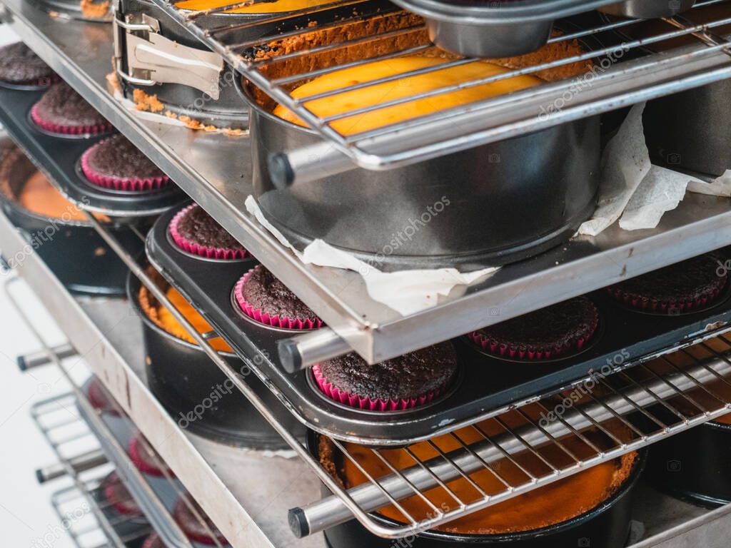 pastelero horneando un gran grupo de pastelitos rellenos de terciopelo