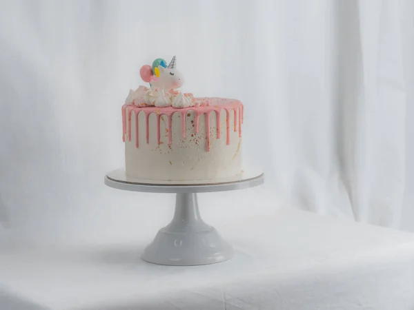 분홍색 서리가 뿌려진 케이크와 유니콘 스프링클러 황금색먹을 수있는 페인트붓을 스탠드에 — 스톡 사진