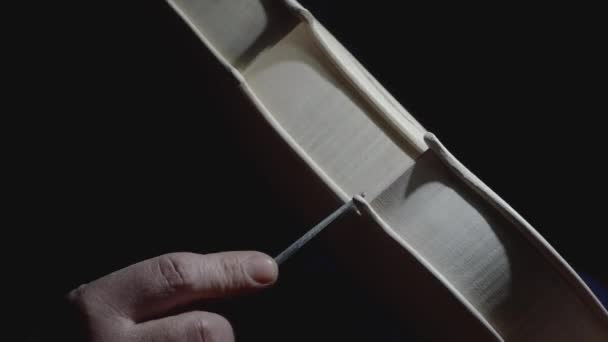 Geigenbauer Handwerker Glätten Rohe Geige Auf Dunklem Hintergrund Filmmaterial — Stockvideo