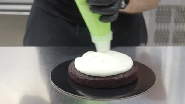 无法辨认的糕点厨师准备糖霜蛋糕 用奶油4K镜头组装海绵黑巧克力层 — 图库视频影像