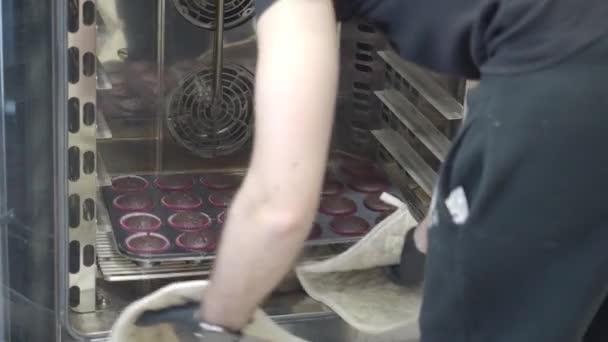 糕点厨师用专业的通风烤箱4K镜头在几个盘子里烤了一大块黑巧克力松饼 — 图库视频影像