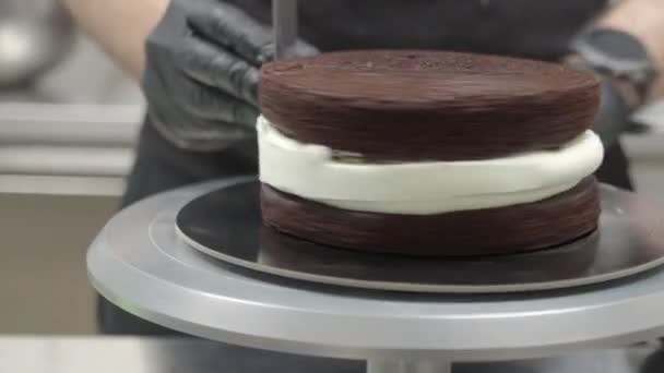 无法辨认的糕点厨师准备糖霜蛋糕 用奶油 焦糖和蛋白块组装海绵黑巧克力层 — 图库视频影像