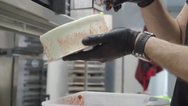 ペストリーシェフデザイナー白焼きアイシングケーキに赤いお菓子を振りかける — ストック動画