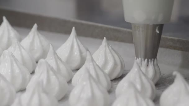 ペストリーシェフパン職人白渦を作ると甘い準備のために焼くために卵の白いクリームと砂糖で満たされた配管袋とツイルメレンゲコーン4Kの映像 — ストック動画