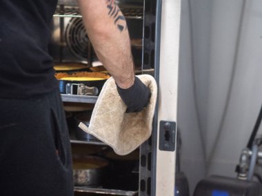 Aşçı fırıncı fırında limonlu turta pişiriyor.