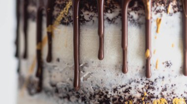 Stüdyo çikolatalı kremalı kek, tatlı meyve soslu ve altın fırça darbeleriyle.