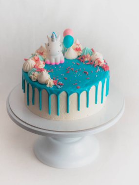 Stüdyo çikolatalı buzlu mavi şekerli pasta, tek boynuzlu at, kremalı pasta ve üzerine serpiştirilmiş şeker.