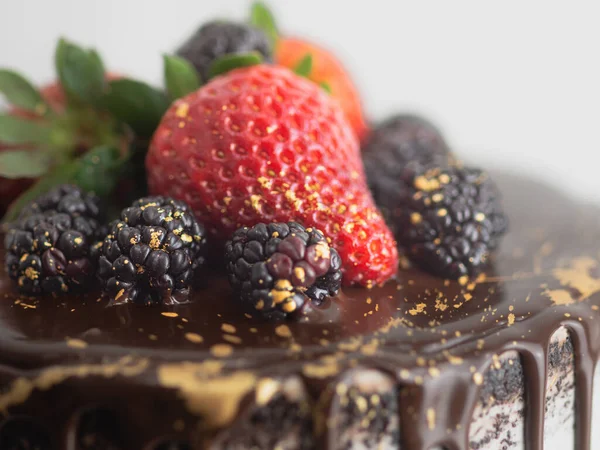 チョコレートのスタジオショット甘いフルーツのトッピングと黄金のブラシストロークとアイスカップケーキを滴下 — ストック写真