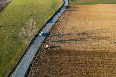 Sürüngen traktörü kullanan çiftçi, geride bir toz bulutunu sürüklüyor, sürme, güç sarsıcı yüzey kabuğu kırılması, bitkilerin kuru toprak üzerinde doğmasını ve tohumlanmasını kolaylaştırıyor.
