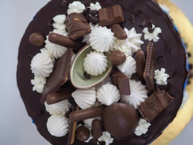 Mavi kremalı pasta makrosu. Kutlama için beyaz arka planda izole edilmiş koyu çikolata kremalı ve karışık şekerli.