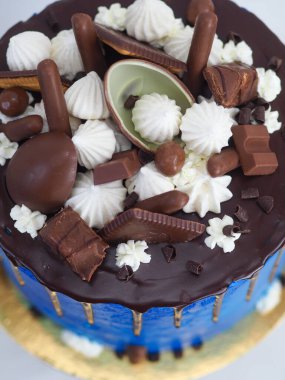 Mavi kremalı pasta makrosu. Kutlama için beyaz arka planda izole edilmiş koyu çikolata kremalı ve karışık şekerli.