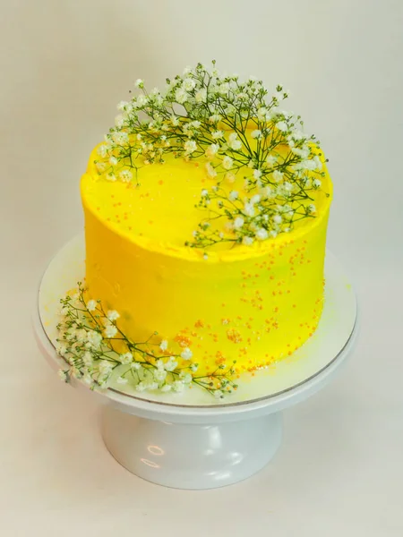 工作室拍摄的黄色庆祝霜冻杯蛋糕 白色背景上孤立的野性白花 — 图库照片