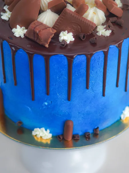 蓝色糖霜蛋糕与黑巧克力糖霜和混合糖果紧密相连 作为白色背景下的顶盖 以庆祝 — 图库照片