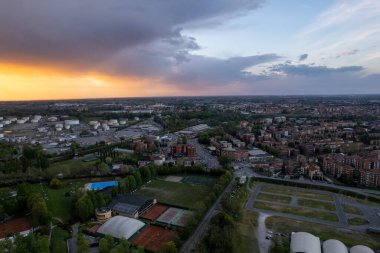 Cremona ve Po nehrinin gün batımında hava aracı görüntüsü, köprü, turuncu gökyüzü, Lombardy, İtalya