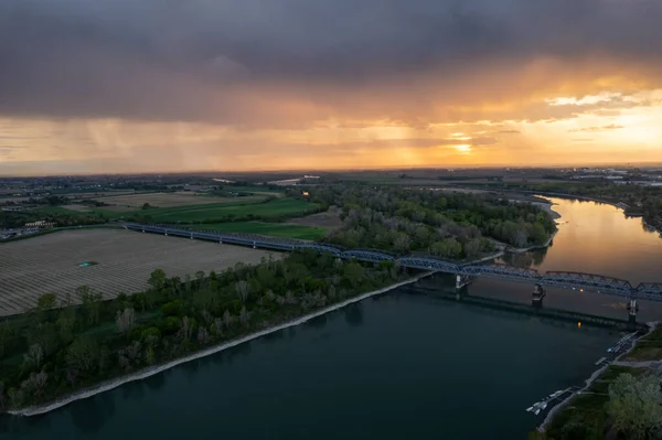 stock image aerial drone shot of Cremona and the river Po at sunset, the bridge, the orange sky, Lombardy, Italy