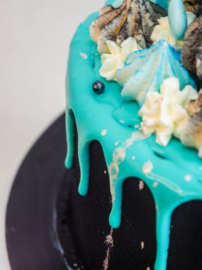 Üzerinde mavi turkuaz damlayan ve renkli el yapımı kremalı pasta stüdyo beyaz izole arka plan.