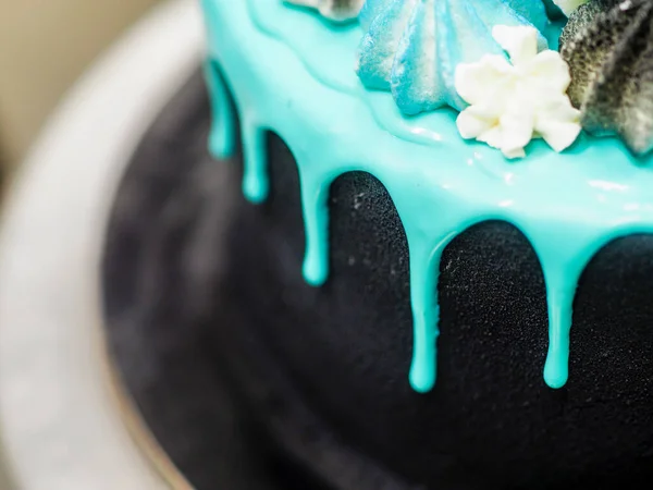 厨师准备用蓝色绿松石水滴和彩色手工调料配上糖霜黑彩绘杯蛋糕 — 图库照片