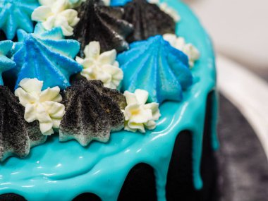 Üzerinde mavi turkuaz damlayan ve renkli el yapımı kremalı pasta stüdyo beyaz izole arka plan.