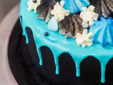 Üzerinde mavi turkuaz damlayan ve renkli el yapımı kremalı pasta stüdyo beyaz izole arka plan.