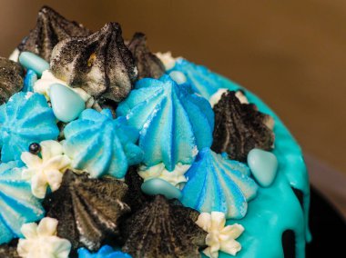 Üzerinde mavi turkuaz damlayan ve renkli el yapımı kremalı pasta stüdyo beyaz izole arka plan.