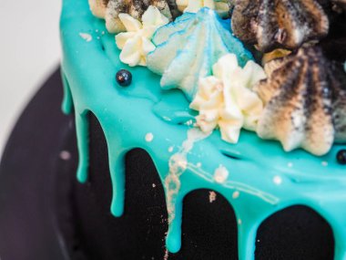 Üzerinde mavi turkuaz damlayan ve renkli el yapımı kremalı pasta stüdyo beyaz izole arka plan.