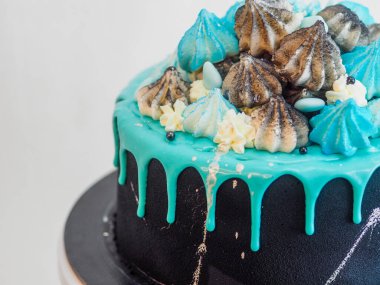 Üzerinde mavi turkuaz damlayan ve renkli el yapımı kremalı pasta stüdyo beyaz izole arka plan.