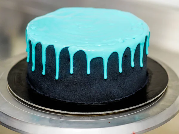 用蓝色绿松石水滴和彩色手工制作的蛋白乳酪蛋糕配上白色孤立的背景制作一个结霜的黑色彩绘杯蛋糕 — 图库照片
