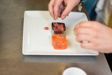 Çiğ somon tartar, alabalık tartar ya da kırmızı balık kübü salatası Macro soslu çiğ ton balığı alabalığı bifteği ya da beyaz restoran tabağında saşimi..