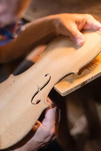 바이올린 제작자는 작업장에서 바이올린 구멍들을 다듬고 자르고 자르는 — 스톡 사진