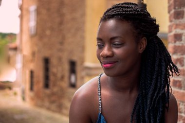 Mutlu siyah kadın gülümsemesi. Şık bir model. Örgü örme saç stili. Neşeli gülümseyen Afrikalı kadın seçici odak noktası açık hava, moda tarzı, mutluluk konsepti. Açık havada..