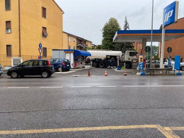 Cremona, İtalya - Mayıs 2023 İtalya 'daki IP servis istasyonuna yakıt ikmali yapan gaz kamyonu yağmurlu bir gün görüntüsü.