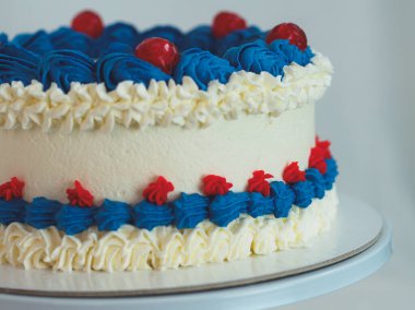 Beyaz arka planda izole edilmiş beyaz mavi kremalı pasta. Amerikan bayrağı renkleri. Kutlama.