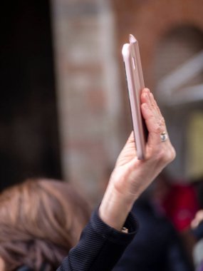 Cremona, İtalya - 9 Aralık 2022 Yetişkinler Bir sokak festivalini kameralı telefonlarla çekiyorlar.