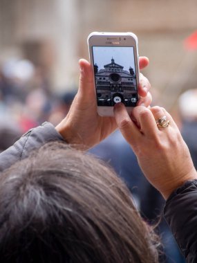 Cremona, İtalya - 9 Aralık 2022 Yetişkinler Bir sokak festivalini kameralı telefonlarla çekiyorlar.