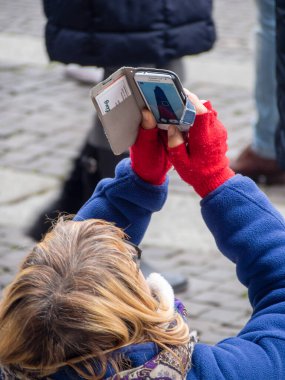 Cremona, İtalya - 9 Aralık 2022 Yetişkinler Bir sokak festivalini kameralı telefonlarla çekiyorlar.