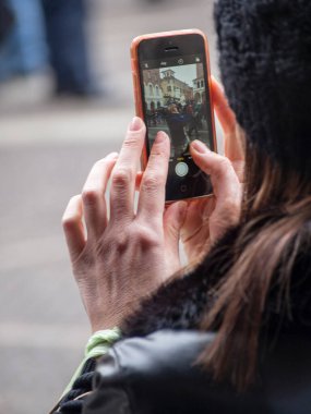Cremona, İtalya - 9 Aralık 2022 Yetişkinler Bir sokak festivalini kameralı telefonlarla çekiyorlar.